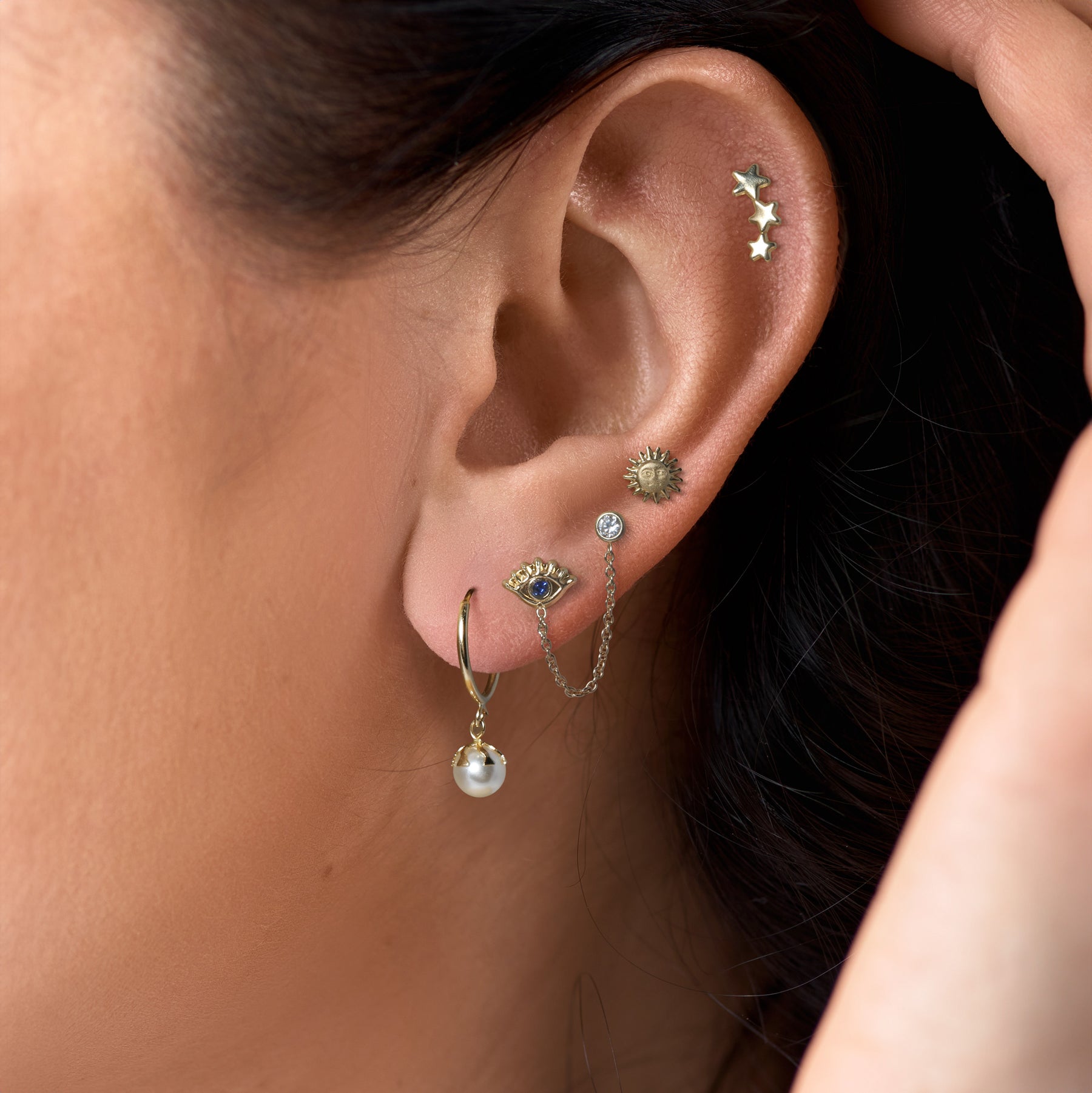 Close of an ear of a woman who is wearing our new 14k gold earrings.